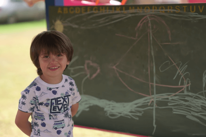 menino desenhando em quadro de lousa