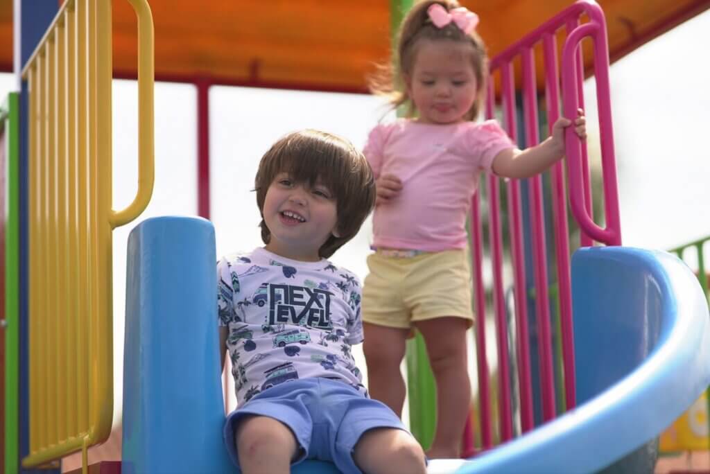 crianças felizes brincando em playground